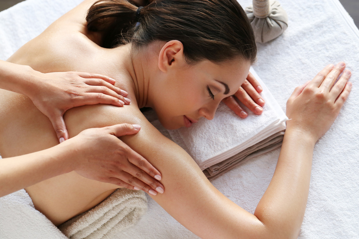 Mujer en salón spa recibiendo masaje
